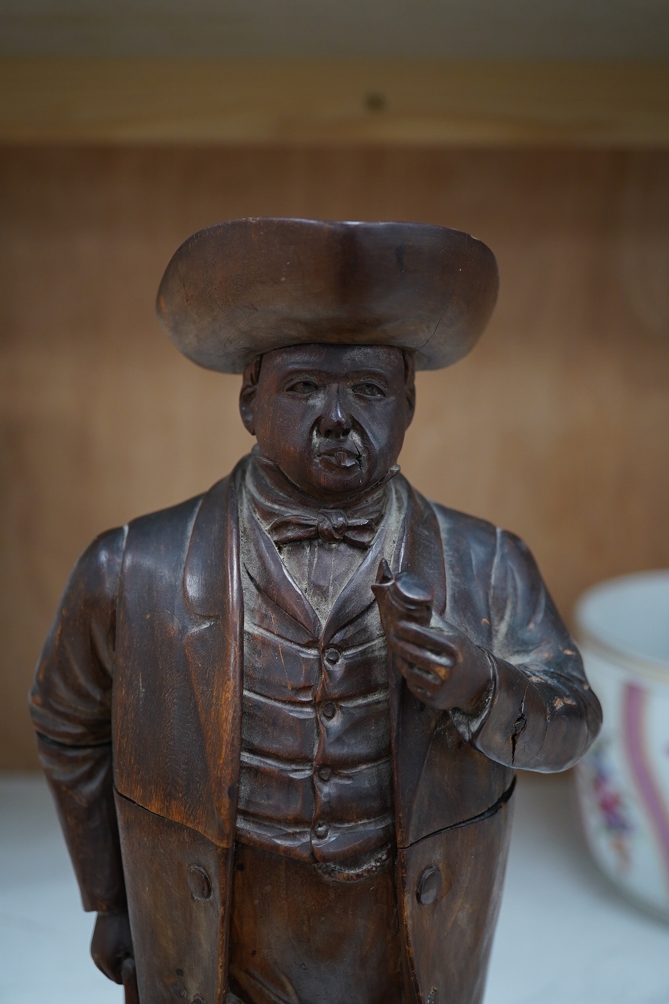 A 19th century Black Forest figure of a gentleman smoking a pipe, hinged at the waist to hold tobacco?, 36.5cm high. Condition - poor to fair, the shaft of his pipe is missing and the rear section of his hat